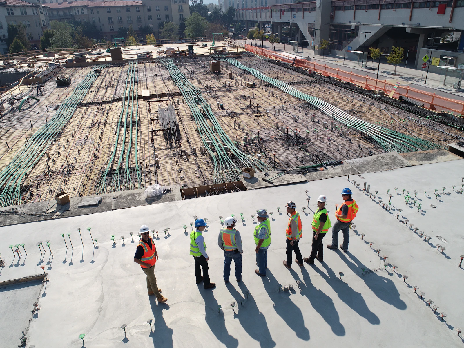 Aerial view of a construction crew standing on a building slab under reinforcement